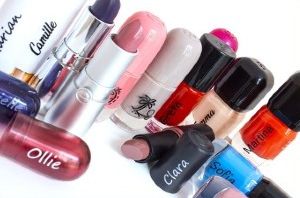Collection of colorful lipsticks and nail polishes with different names and designs printed on them.